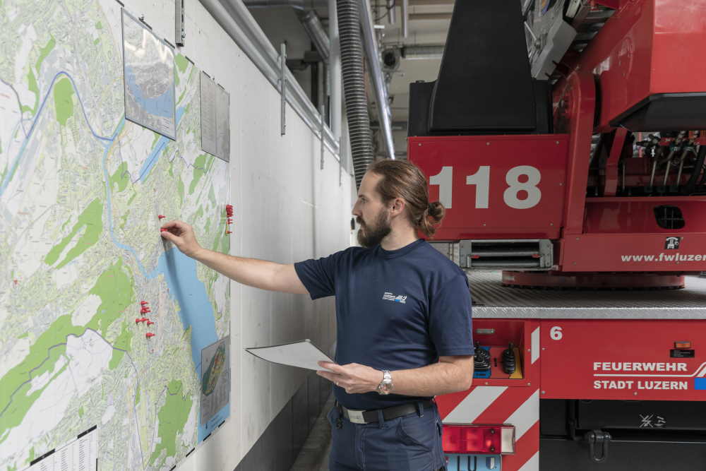 Ein Mann studiert einen Stadtplan in einem Feuerwehrdepot.