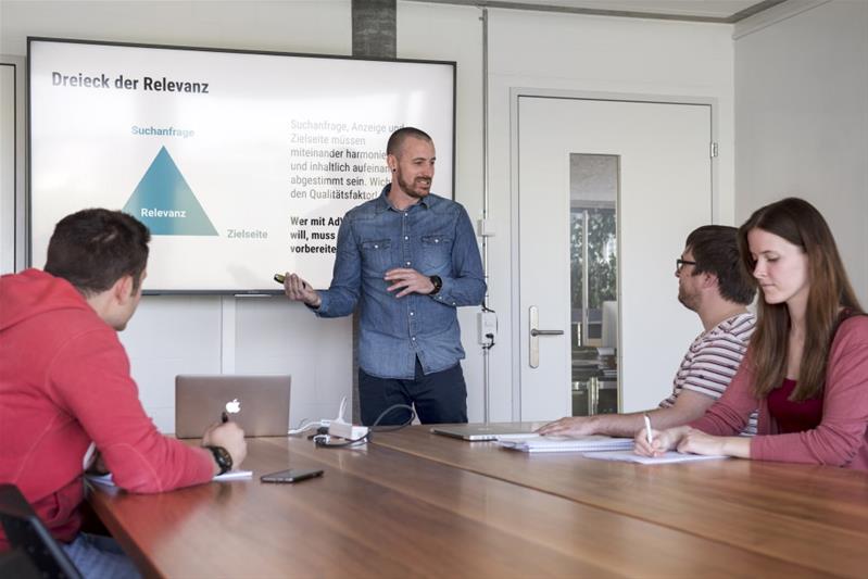 Ein Mann leitet eine Sitzung mit Hilfe einer Powerpoint-Präsentation.