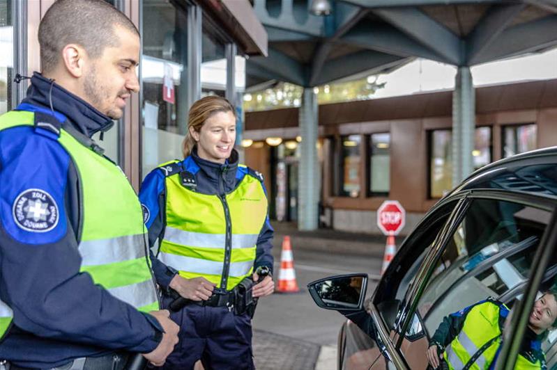 Grenzwächter führen einen Gespräch mit einem Autofahrer.