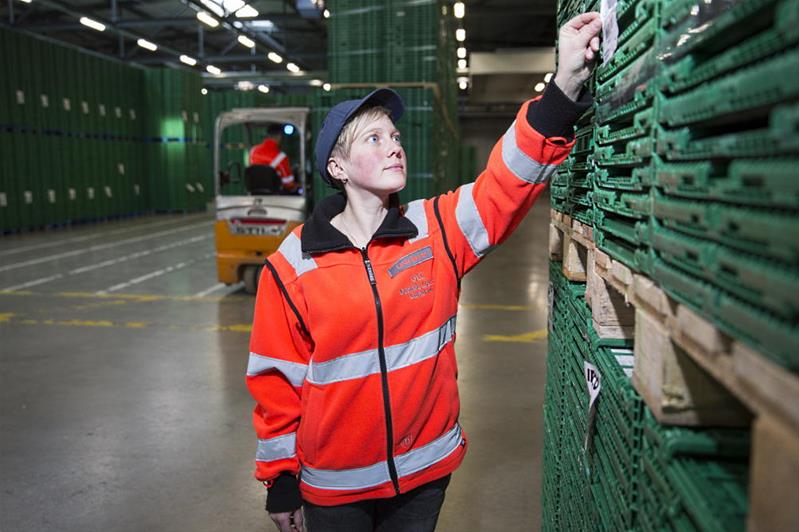 Eine junge Frau überprüft die Etikettierung einer Palette in einem Warenlager.