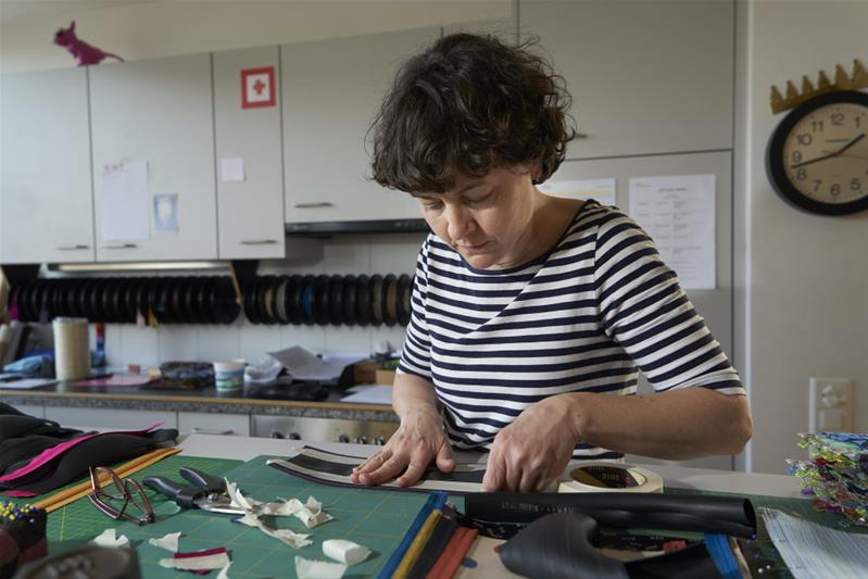 Eine Frau entwirft eine Textilprodukt im Atelier.
