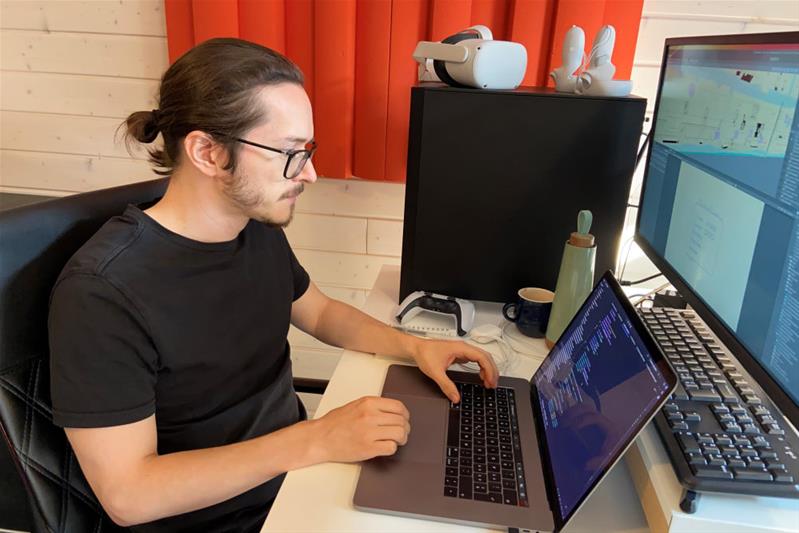 Ein Mann schreibt Computercodes auf einem Computer.