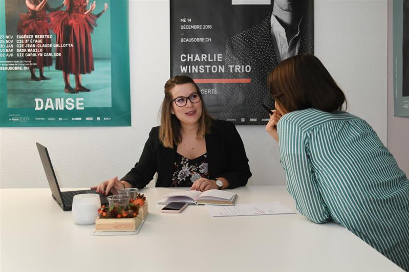 Zwei Frauen sitzen an einem Tisch und reden miteinander.