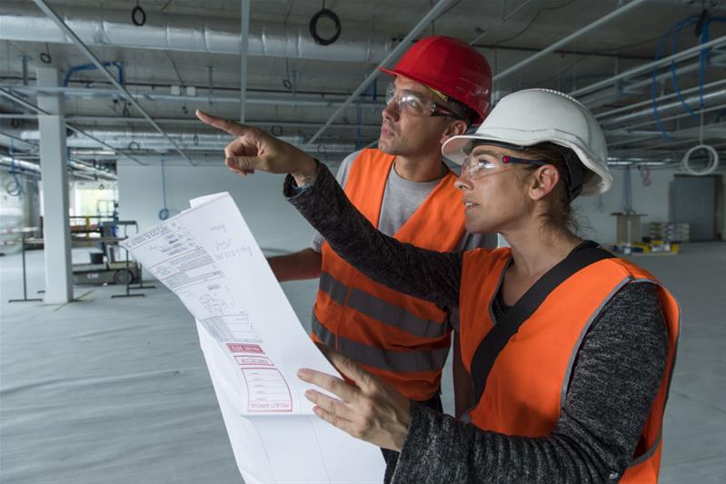 Zwei Berufsleute begutachten den Rohbau, in welchem sie die Arbeiten ausführen müssen.