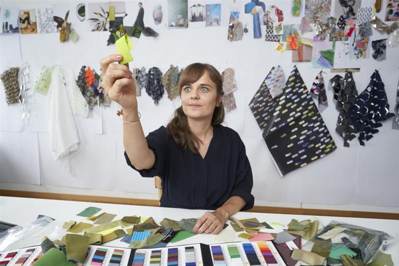 Judith Röllin betrachtet Stoffmuster.